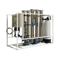 Crystal Quest 10,000 GPD commercial RO system with stainless steel housings, white frame, and blue accents.