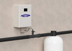 Crystal Quest OxiOrg whole-house water oxidation ozone system, a white wall-mounted unit with blue logo, connected to black piping.