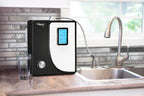 Tyent Hybrid countertop water ionizer installed beside kitchen sink with glass backsplash
