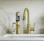 Tyent UCE-13 PLUS Gold built-in water ionizer faucet dispensing water beside a gold kitchen faucet